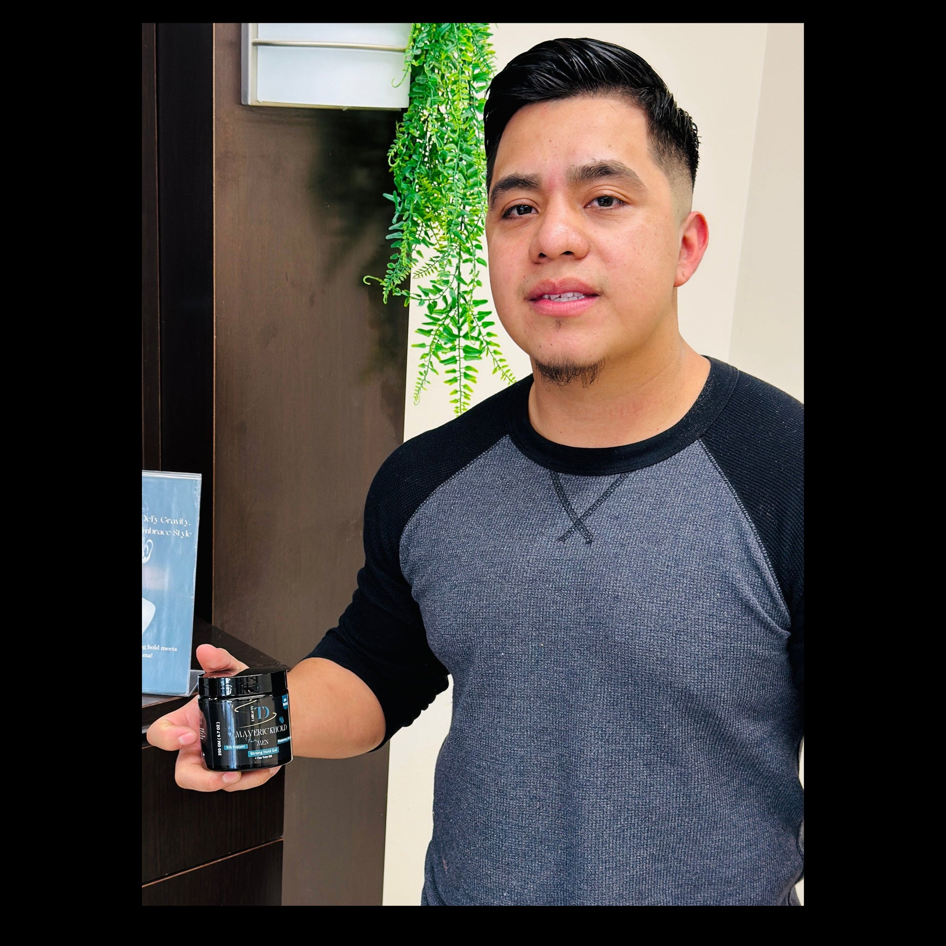 Man with styled hair holding a jar of anti hair fall strong hold hair Gel in a salon setting